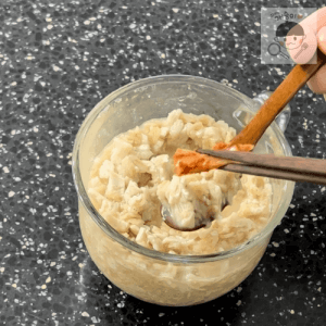 完成したダイエットオートミールチキンポタージュをスプーン一杯ずつ盛り付け、その上にキムチ一枚を乗せる様子。