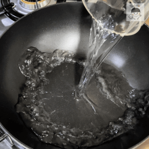 フライパンに水を注ぐシーン
