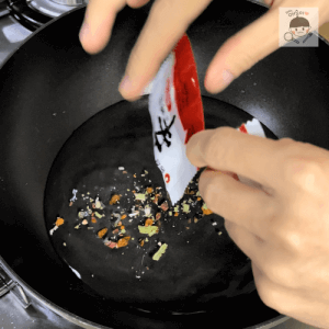 粉末スープをフライパンに入れるシーン