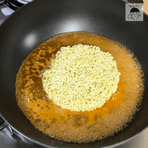 ラーメンのサリーをフライパンに入れるシーン