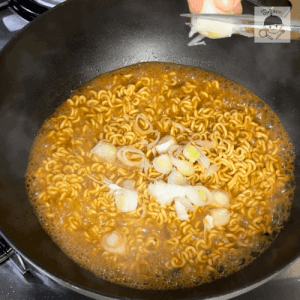 ネギをはさみで切ってラーメンの上に乗せるシーン