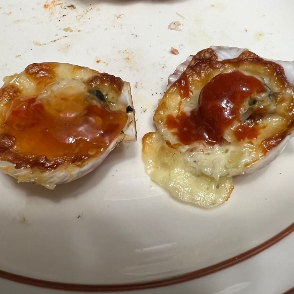 完成したホタテチーズオーブン焼きにスイートチリソースと酢醤油を一つずつ塗った様子。