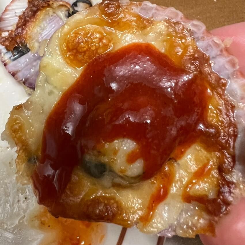 帆立貝のチーズオーブン焼きにたっぷりの酢の物を乗せた様子