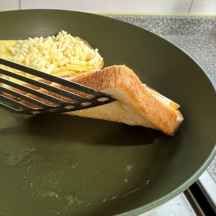 식빵의 아랫면을 뒤집개로 들어서 식빵의 굽기를 확인하는 모습