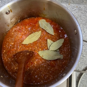 토마토 소스에 월계수 잎을 넣고 조리하는 모습