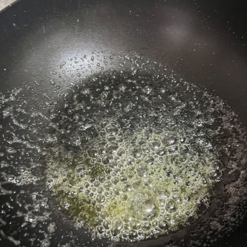 Butter bubbling and melting on a hot pan.