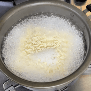 沸騰したお湯で茹でられるブルドックフライドチキンラーメン
