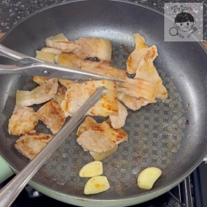 ハサミで豚バラ肉を一口大に切る様子