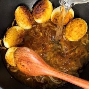 カレーを沸騰させながら水を加えるシーン