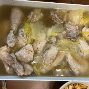 煮込んだ鶏肉と白菜が入った鍋に出汁が入った鍋