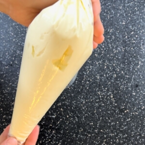 クリームを詰めた絞り袋を手にした様子