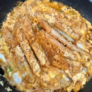 Kimchi tonkatsu nabe, una combinación de huevo cocido y chuleta de cerdo en un caldo de kimchi