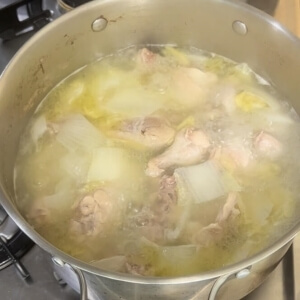沸騰している一羽の鶏のスープ