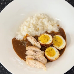 ご飯の上に卵カレーと鶏の胸肉を乗せたプレート