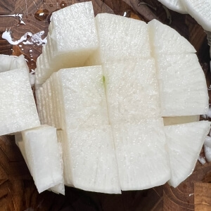 牛肉スープに入れるために大根をさいの目に切って準備した様子。