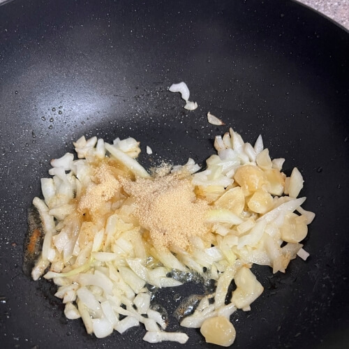 Garlic, onion, and sugar sautéing in a pan.