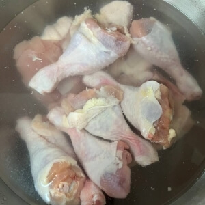 鶏の脚を水に浸して血を抜く。