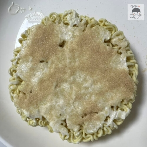 マヨネーズが塗られたラーメンの上に砂糖をたっぷりかけた様子。