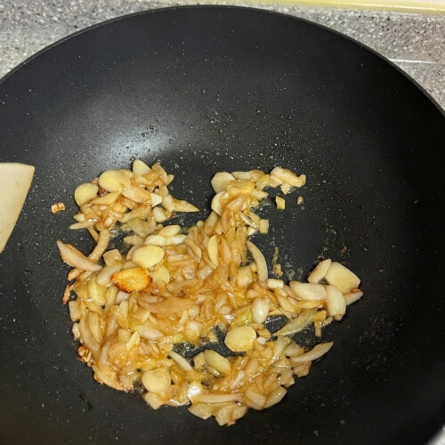 Garlic and onions sautéed to a golden color in a pan.
