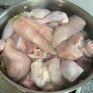 水に浸した鶏肉と野菜が入ったポット