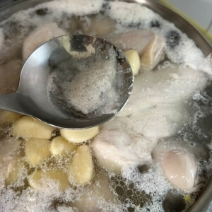 スープに浮かび上がった泡を取り除く工程