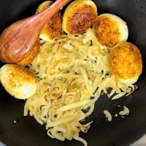 玉ねぎと卵が一緒に炒められる様子