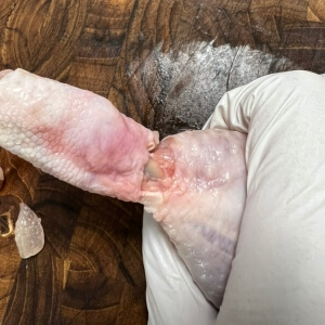 닭다리 껍질과 살을 뒤집어서 손질하는 모습