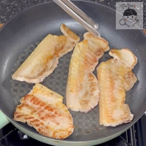 フライパンで焼かれている豚バラ肉