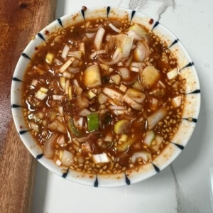 豆腐の煮込みの味付けソースを準備する様子