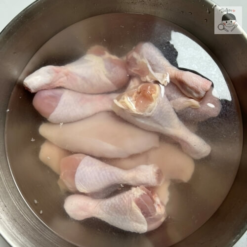 Pollo crudo remojado en agua sobre un escurridor