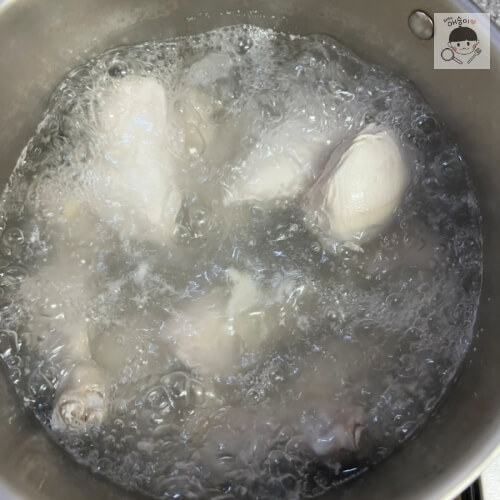 Pollo y agua hirviendo en una cacerola