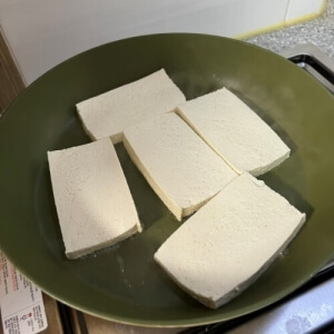 豆腐煮込み用の豆腐をフライパンで焼いて準備する工程