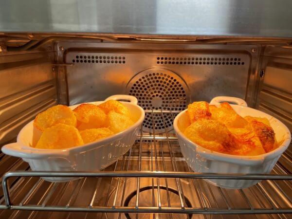 チーズオーブンローストポテトレシピを完成させた様子。オーブンの中に黄金色に焼かれたジャガイモが完成している。