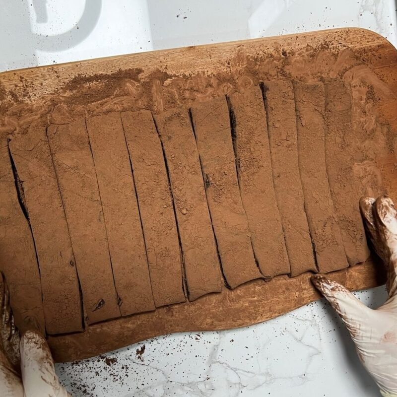 Chocolate chunks sprinkled with cocoa powder, cut into uniform lengthwise slices