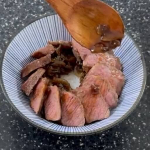 ステーキと煮込み醤油ソースを乗せた様子