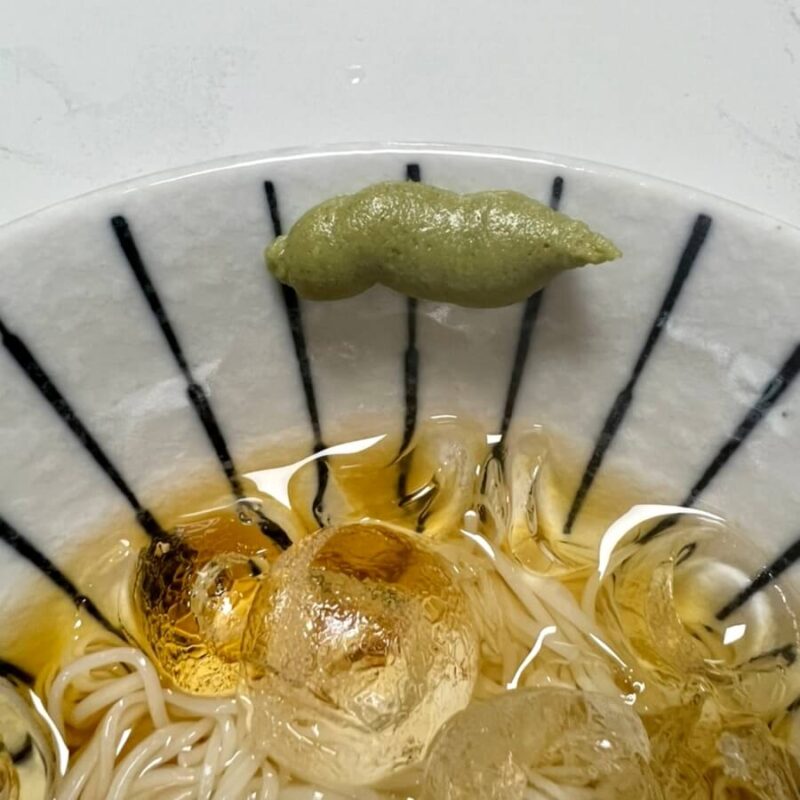 Lotus wasabi woven into the corner of a bowl of somen noodles.