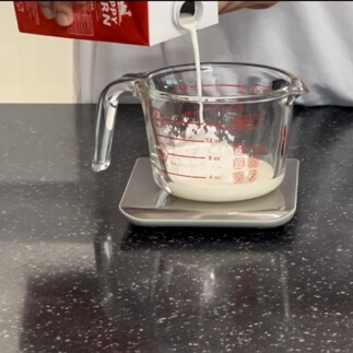Pouring milk into starchy flour