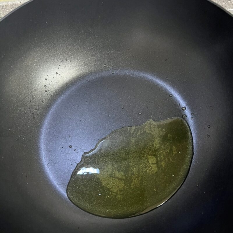 予熱したフライパンにオリーブオイルを塗って準備する様子。