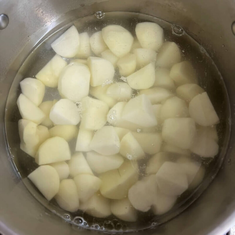 鍋にジャガイモと水を入れた様子。 ジャガイモが水に浸かっている。