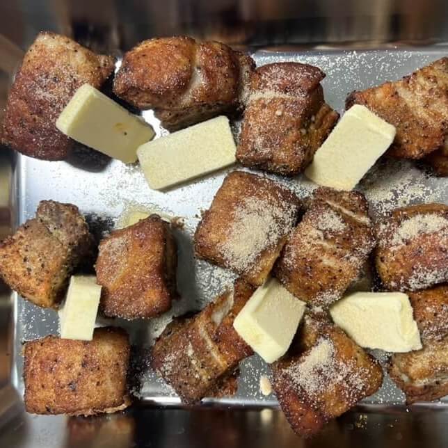 焼いた豚バラ肉に砂糖とバターを入れた様子