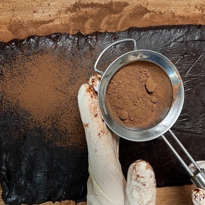 Sprinkling cocoa powder on the chocolate chunks
