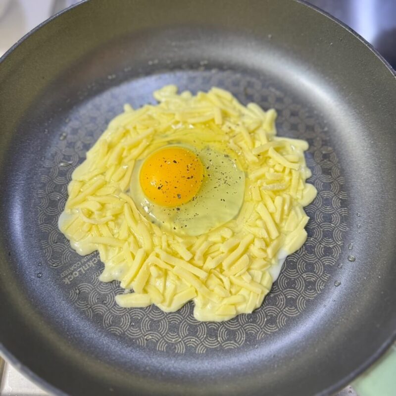 An egg in a round hole in mozzarella cheese.