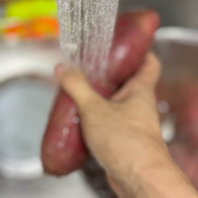 Washing sweet potatoes under running water