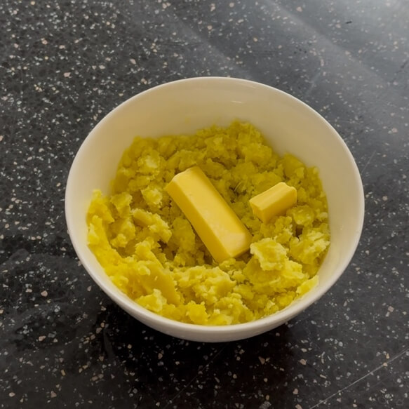 Adding butter to mashed sweet potato