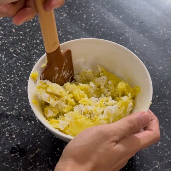 Mixing the mashed sweet potato with the starchy flour.
