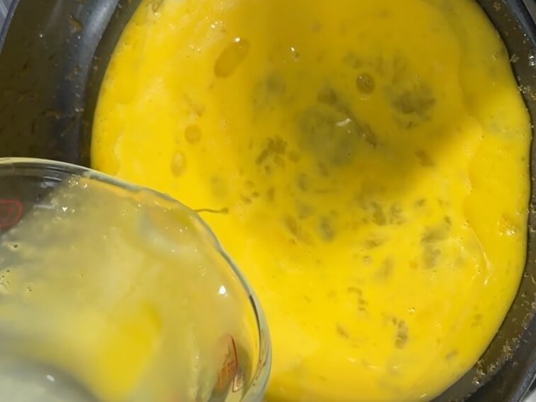 Adding the egg wash to the pan