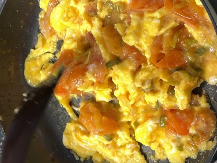 Tomato fried egg cooking on residual heat