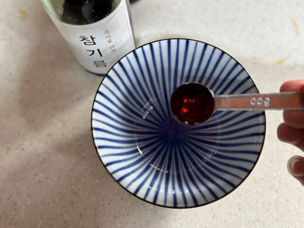 ボウルにごま油を入れる様子