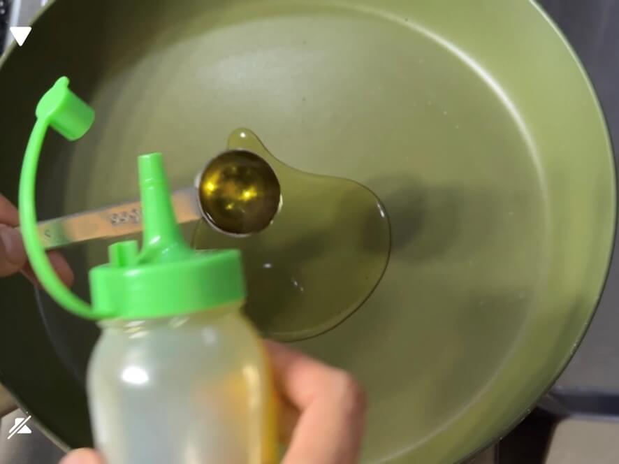 フライパンに食用油を入れる様子