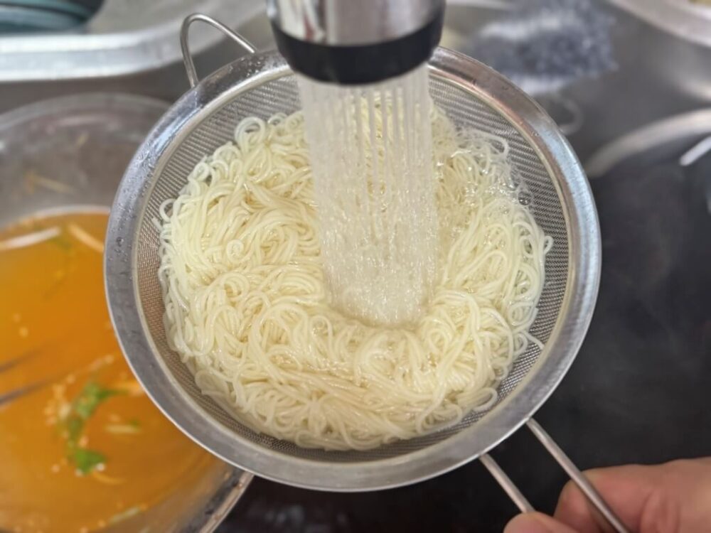 素麺を冷水ですすいでいる様子 